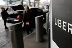 In this March 15, 2017, file photo, a sign marks a pick-up point for the Uber car service at LaGuardia Airport in New York. The New York Times and other media are reporting Sunday, June 11, 2017, that Uber's board is considering placing Kalanick, the CEO of the ride-hailing company, on leave.