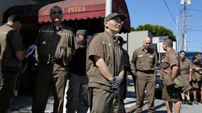 UPS workers gather outside a UPS package delivery warehouse where a shooting took place Wednesday, June 14, 2017, in San Francisco. A UPS spokesman says four people were injured in the shooting at the facility and that the shooter was an employee.