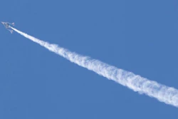 VSS Unity in-flight showing a contrail as water was released from the aft ballast tank.