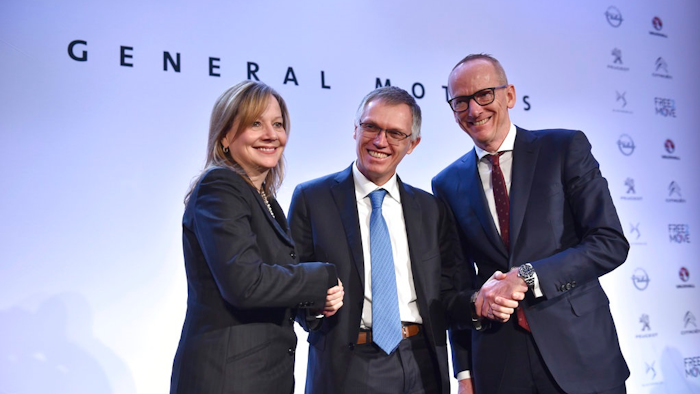 In this March 6, 2017 file photo CEO of PSA Carlos Tavares, Opel CEO Karl-Thomas Neumann, right, and GM CEO Mary Barra, left, pose for photographers after addressing the media in Paris, France. On Wednesday, July 5, 2017 the European Union has approved French automaker PSA's acquisition of Opel and British brand Vauxhall from General Motors. The EU's executive Commission said it has given unconditional approval to the deal.