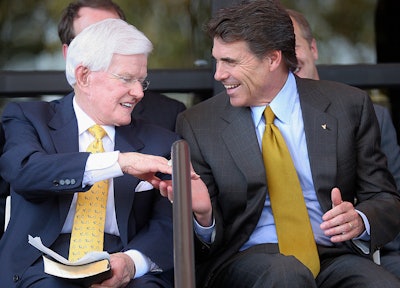 In this Sept. 18, 2005, photo, Lonnie 'Bo' Pilgrim, CEO and Chairman of the Board of Board of Pilgrim's Pride Chicken, left, shakes hands with Texas Gov. Rick Perry at the Dedication Open House of the companies new headquarters in Pittsburg, Texas. Pilgrim, who grew a one-time feed store into the world's largest poultry producer before losing the company in bankruptcy, has died at 89. A statement on the Erman Smith Funeral Home website says Pilgrim died Friday, July 21, 2017, at his Pittsburg home.