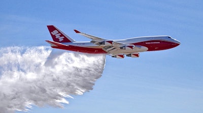 This May 5, 2016, photo provided by Global Supertanker Services shows a Boeing 747 making a demonstration water drop at Colorado Springs Airport in Colorado Springs, Colo. The company with the 747 retardant bomber that can drop nearly 20,000 gallons (75,000 liters) on wildfires says federal officials are keeping it grounded, putting homes and ground-based firefighters at risk. Officials with Global SuperTanker filed a protest with the U.S. Forest Service in June 2017 contesting a contract limiting firefighting aircraft to 5,000 gallons.