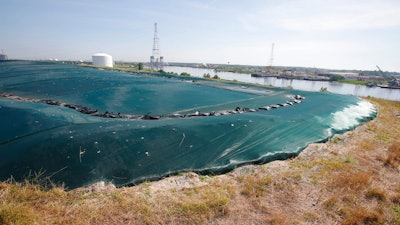 This Monday June 27, 2016 file photo shows a non-permeable cover tops Coal Ash Basin B along the banks of the Elizabeth River in Chesapeake, Va.A federal judge has ordered Virginia's largest utility to conduct two years of water, sediment and biological tissue sampling at the Chesapeake Energy Center, where he ruled earlier this year coal ash is polluting surrounding waters with arsenic.