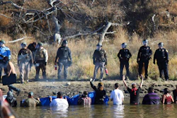 In this Nov. 2, 2016 file photo, protesters demonstrating against the expansion of the Dakota Access pipeline wade in cold creek waters confront local police near Cannon Ball, N.D. Industry officials say protests like the one involving the disputed pipeline may be commonplace in the future. The recently completed $3.8 billion pipeline that's opposed by American Indian tribes and others was discussed Wednesday, July 19, 2017, at an annual oil industry conference in Bismarck with a panel dissecting what was learned from the nearly year-long struggle over building it in North Dakota.