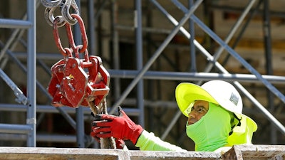 In this Thursday, June 15, 2017, photo, a construction worker continues work on a condominium project in Coral Gables, Fla. On Friday, July 7, 2017, the Labor Department will release the U.S. jobs report for June.