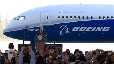 In this Friday, Feb. 17, 2017, file photo, U.S. President Donald Trump speaks in front of a Boeing 787 Dreamliner while visiting the Boeing South Carolina facility in North Charleston, S.C. Trump’s push to get Americans to embrace goods “Made in USA” is harder than it looks. Few products are American-made only. Trump himself signs laws with gold-plated pens assembled in Rhode Island but lacquered and engraved in China. He praises U.S. industrial might in front of a Boeing jet whose parts are 30 percent foreign-made. And there’s a good reason why this is the case: U.S. manufacturers rely on global supply chains and Americans buy foreign goods because they prefer lower prices.