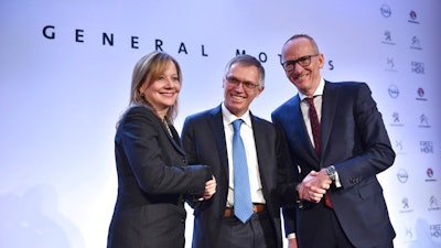 In this March 6, 2017 file photo CEO of PSA Carlos Tavares, Opel CEO Karl-Thomas Neumann, right, and GM CEO Mary Barra, left, pose for photographers after addressing the media in Paris, France. On Wednesday, July 5, 2017 the European Union has approved French automaker PSA's acquisition of Opel and British brand Vauxhall from General Motors. The EU's executive Commission said it has given unconditional approval to the deal.