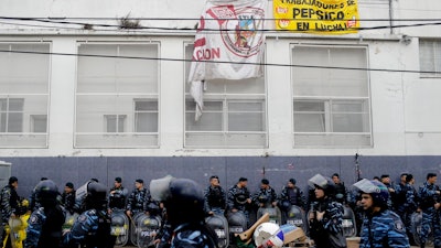 Hundreds of police and security agents with anti-riot gear gather outside the PepsiCo plant on the outskirts of Buenos Aires, Argentina, Thursday, July 13, 2017. Security forces clashed Thursday with former PepsiCo employees after resisting eviction from the plant. Workers had occupied the plant after PepsiCo closed the plant last month for logistical reasons.