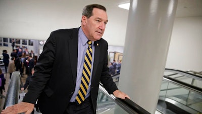 In this April 7, 2017, file photo, U.S. Sen. Joe Donnelly, D-Ind., arrives for the confirmation vote for Supreme Court nominee, Neil Gorsuch, on Capitol Hill in Washington. Donnelly railed against Carrier Corp. for moving manufacturing jobs to Mexico last year, even while he profited from a family business that relies on Mexican labor to produce dye for ink pads, according to records reviewed by The Associated Press.