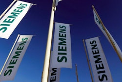 In this Jan. 23, 2013 file photo flags of German engineering conglomerate Siemens AG fly during an annual shareholder meeting in Munich, southern Germany. German industrial conglomerate Siemens AG says Friday, July 21, 2017 it’s halting deliveries of power generation equipment to state-controlled companies in Russia and selling its stake in a Russian company that offers services for power plant control systems.