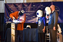 This photo provided by the US Navy shows Stephen Corr welding the outline of Dana Richardson’s initials on the Oregon keel as Dana and Electric Boat President Jeff Geiger look on Saturday July 8, 2017, in North Kingstown, R.I.