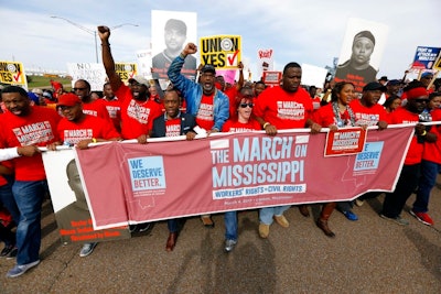 In this March 4, 2017, file photograph, auto workers and others march to Nissan Motor Co.'s Canton, Miss., plant, following a pro-union rally. A bid by workers at Mississippi's Nissan Motor Co. plant for United Auto Workers representation could turn on a key voting bloc: the 1,500 Nissan employees who were initially hired through contract labor agencies.