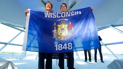 Foxconn Chairman Terry Gou, left, and Gov. Scott Walker hold the Wisconsin flag to celebrate their $10 billion investment to build a display panel plant in Wisconsin, at the Milwaukee Art Museum in Milwaukee, Wis., Thursday, July 27, 2017.
