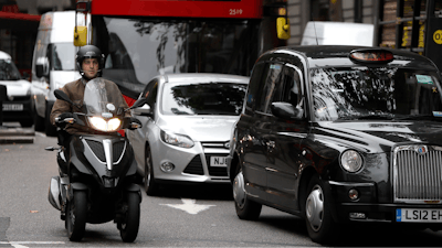 Vehicles drive in central London, Wednesday, July 26, 2017. To control air pollution, new diesel and petrol cars and vans could be banned in the UK from 2040.