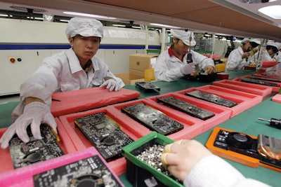 In this May 26, 2010 file photo, staff members work on the production line at the Foxconn complex in the southern Chinese city of Shenzhen, Southern city in China.