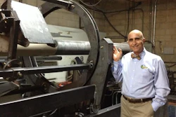 InfinitPipe inventor and QuakeWrap, Inc. President Dr. Mo Ehsani stands next to the prototype of the machine that makes continuous, on-site pipe manufacturing possible, including from truck or boat.