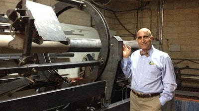 InfinitPipe inventor and QuakeWrap, Inc. President Dr. Mo Ehsani stands next to the prototype of the machine that makes continuous, on-site pipe manufacturing possible, including from truck or boat.