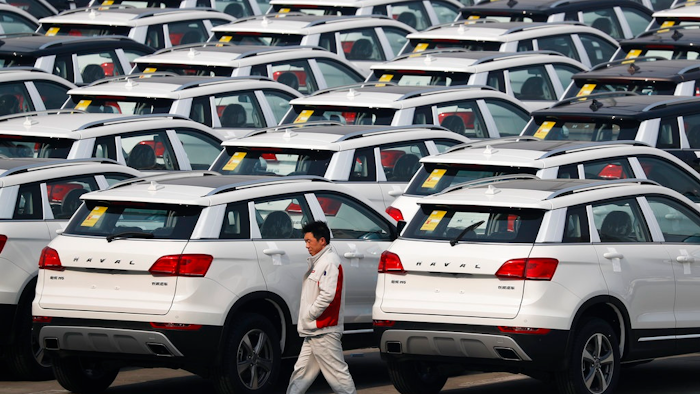 In this Feb. 19, 2017, file photo, a worker walks past Haval SUV models parked outside the Great Wall Motors assembly plant in Baoding in north China's Hebei province. Chinese SUV maker Great Wall Motors is considering making a bid to acquire Fiat Chrysler's Jeep unit, two employees of the Chinese company said Monday, Aug. 21, 2017 in an ambitious new move for the country's fast-growing domestic auto brands. Great Wall has yet to make a formal announcement of its interest in Jeep but a possible acquisition would be in line with chairman Wang Jianjun's goal, announced in February, of becoming the top specialty SUV producer by 2020.