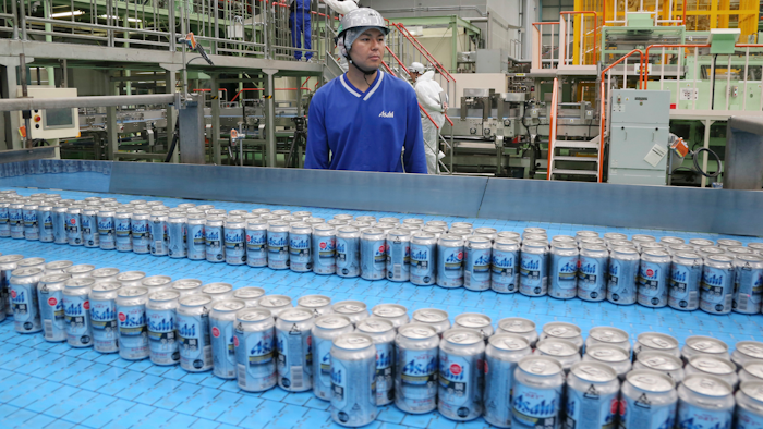 In this Monday, May 29, 2017 photo, Asahi Breweries plant manager Shinichi Uno watches the production line at an Asahi Breweries factory in Moriya near Tokyo. The human job is to make sure the machines do the work right, and to check on the quality the sensors are monitoring. “Basically, nothing goes wrong. The lines are up and running 96 percent,” says Uno. “Although machines make things, human beings oversee the machines.”