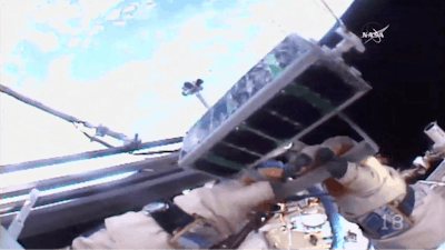 In this image made from video provided by NASA, Russian cosmonaut Sergei Ryazansky holds a mini satellite before launching it by hand from the International Space Station on Thursday, Aug. 17, 2017.