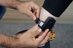 An employee demonstrates how an electronic bracelet works at the Sao Paulo-based Synergye, a company that makes the bracelets and monitors inmates.
