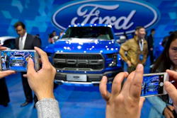 1 0 In this April 23, 2016, photo, attendees take smartphone photos at a promotional event for Ford Motor Company ahead of the Auto China car show in Beijing. Ford Motor Co. announced an agreement Tuesday, Aug. 22, 2017 with a Chinese partner to look into forming a joint venture to develop and manufacture electric cars in China.