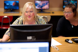 In this Thursday, July 27, 2017, photo, Cheryl Bast, left, is accompanied by her daughter Liz Pierson, as she works on an application for a position with Omaha Public Schools, during a job fair held at Omaha South High School in Omaha, Neb. On Friday, Aug. 4, 2017, the U.S. government issues the July jobs report.