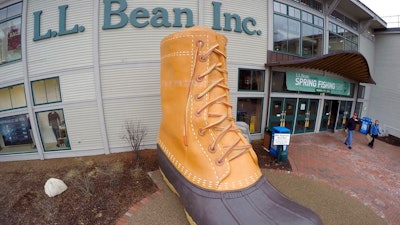 In this March 16, 2016, file photo, shoppers exit the L.L. Bean retail store in Freeport, Maine. L.L. Bean hopes to give the boot to backlogs of its most iconic product. The Maine-based retailer is expanding production to keep up with demand for its leather-and-rubber “duck boot” with a new manufacturing center that’s being unveiled Thursday, Aug. 17, 2017. The company also plans to hire more than 100 additional production workers at two locations in Maine.