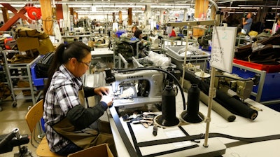 In this Wednesday, Aug. 31, 2016, file photo, a worker at the C.C. Filson Co. manufacturing facility stitches a belt at a sewing machine, in Seattle. On Thursday, Aug. 17, 2017, the Federal Reserve reports on U.S. industrial production for July.