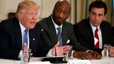 In this file photo, President Donald Trump, left, speaks during a meeting with manufacturing executives at the White House, including Merck CEO Kenneth Frazier, center, and former Ford CEO Mark Fields. Frazier is resigning from the President’s American Manufacturing Council.