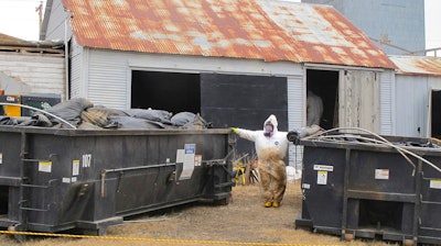 In this file photo taken April 23, 2014, white-suited workers wearing respirators clean up the illegal filter sock dump in an abandoned gas station in Noonan, N.D., near the Canadian border. Federal officials say fugitive James Ward, who escaped custody in Wyoming four years ago, is being sought for the illegal dumping of radioactive oilfield waste in North Dakota.