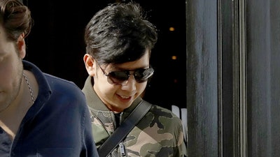 In this April 5, 2017, file photo, Vorayuth 'Boss' Yoovidhya, whose grandfather co-founded energy drink company Red Bull, walks to get in a car as he leaves a house in London. The Bangkok billionaire family uses offshore companies to cloak purchases of jets and luxury properties, including the posh London home where the clan’s fugitive son was last seen. The Yoovidhya family’s efforts to hide assets show how easily major global financial players can routinely - and, usually, legally - move billions of dollars with little or no oversight.
