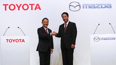 Toyota Motor Corp. President Akio Toyoda, left, and Mazda Motor Corp. President Masamichi Kogai, pose for media prior to a press conference in Tokyo Friday, Aug. 4, 2017. Japanese automakers Toyota Motor Corp. and Mazda Motor Corp. said Friday they plan to spend $1.6 billion to set up a joint-venture auto manufacturing plant in the U.S. — a move that will create up to 4,000 jobs.