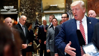 White House chief of staff John Kelly, left, watches as President Donald Trump speaks to the media in the lobby of Trump Tower, Tuesday, Aug. 15, 2017 in New York.