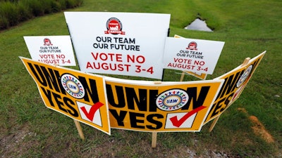 In this Tuesday, Aug. 1, 2017, photo, UAW members use their signs to block Nissan company signs at one of the entrances to the vehicle assembly plant in Canton, Miss. In voting that begins early Thursday, Aug. 3, some 3,700 direct employees at the Nissan plant will decide whether they want a union. The polls close at 7 p.m., local time on Friday.