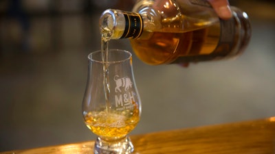 In this Thursday, Aug. 10, 2017 photo, whiskey is poured at the 'Milk and Honey' whiskey distillery in Tel Aviv, Israel. Israel has been known as the land of milk and honey since Biblical times. But could it become known as the land of single malt whiskey? One appropriately named distillery is trying to turn Israel into a whiskey powerhouse.