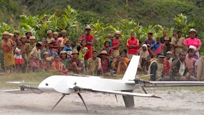 In this July 27, 2016, file frame from video provided by Vayu, Inc., residents from Ranomafana, Madagascar, watch before a drone containing medical samples takes off on a test flight from their remote village, which can only be reached on foot. Off Africa’s eastern coast in Madagascar, U.S. company Vayu completed drone flights to deliver blood and stool samples from rural villages, with support from the U.S. Agency for International Development.