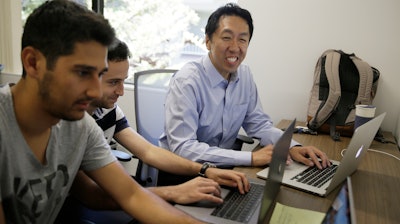 In this Friday, July 14, 2017, photo, computer scientist Andrew Ng, right, works with others at his office in Palo Alto, Calif. Ng, one of the world's most renowned researchers in machine learning and artificial intelligence, is facing a dilemma: there aren't enough experts trained to train the machines. So when he isn't pushing into the frontier of AI himself, Ng is building new ways to help educate the next generation of AI specialists.
