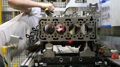 A Ford employee quality checks cylinder holes of a two liter diesel engine, at the Ford Dagenham diesel engine plant in London, Friday, July 21, 2017. Ford’s Dagenham diesel engine plant is a marvel of mechanization _ a steel and chrome hangar full of LED lighting, robots and computer-controlled machine tools. The U.S. carmaker has invested $2.5 billion in the plant, where 3,150 people churn out an engine every 30 seconds.