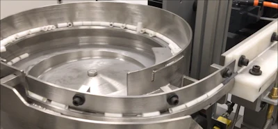 A bowl feeder introduces the alumina spacers to the conveyor.