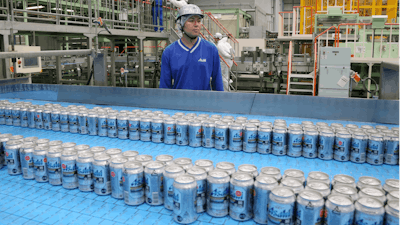 In this Monday, May 29, 2017 photo, Asahi Breweries plant manager Shinichi Uno watches the production line at an Asahi Breweries factory in Moriya near Tokyo. The human job is to make sure the machines do the work right, and to check on the quality the sensors are monitoring. “Basically, nothing goes wrong. The lines are up and running 96 percent,” says Uno. “Although machines make things, human beings oversee the machines.”