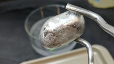 A researcher holds up a piece of magnesium.