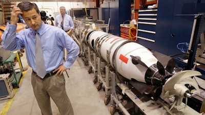 In this Tuesday, July 31, 2012 file photo, Christopher Del Mastro, head of anti submarine warfare mobil targets stands next to an unmanned underwater vehicle (UUV) in a lab at the Naval Undersea War Center in Middletown, RI. President Donald Trump and U.S. Navy leaders have said that the nation needs about 350 ships, roughly 75 more ships than the fleet has today. Adm. John Richardson, chief of naval operations, said they could get closer to the Navy's goal by counting unmanned vehicles that have capabilities similar to a manned ship.