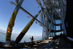 In this photo taken Tuesday, July 11, 2017, a woman looks out toward the San Francisco-Oakland Bay Bridge from just below the top of the Salesforce Tower in San Francisco. Construction crews are putting the finishing touches on San Francisco’s new tallest building. The 61-story Salesforce Tower and an adjacent transit center represent a shift in San Francisco, one that pits the technology industry against the city’s charming neighborhoods.