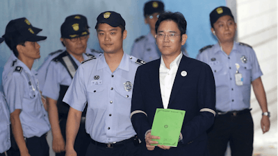 Lee Jae-yong, second from right, vice chairman of Samsung Electronics Co., arrives for his trial at the Seoul Central District Court in Seoul, South Korea, Monday, Aug. 7, 2017. South Korean prosecutors recommended imprisoning a billionaire Samsung heir for 12 years on Monday, asking court to convict him of bribery and other crimes in a national corruption scandal.