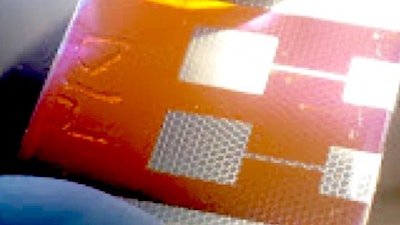 A compound solar cell illuminated from a light source below. Hexagonal scaffolds are visible in the regions coated by a silver electrode. The new solar cell design could help scientists overcome a major roadblock to the development of perovskite photovoltaics.