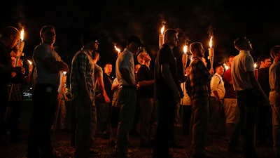 In this Friday, Aug. 11, 2017 photo, multiple white nationalist groups march with torches through the UVA campus in Charlottesville, Va. W.C. Bradley Co. President and CEO Marc Olivie told the Columbus Ledger-Enquirer on Monday, Aug. 14 that the Columbus-based company’s staff was “appalled and saddened” that its Tiki brand torches were “used by people who promote bigotry and hatred.”