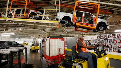 Vehicles are suspended above other installation stations as they are moved along the assembly line at the Nissan Canton Vehicle Assembly Plant.