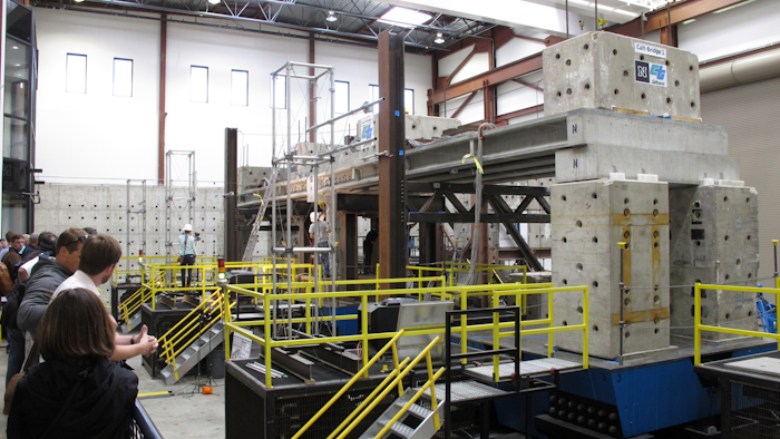 Researchers and invited dignitaries watch gathered at the University of Nevada, Reno's new Earthquake Engineering Laboratory in Reno, Nev., on Wednesday, Sept. 20, 2017, before a series of tests on new bridge designs intended to better withstand violent temblors. Scientists say the 100-ton, 70-foot-long concrete bridge subjected to violent motions on a giant ''shake table'' held up better than expected using new innovations to connect prefabricated pieces with ultra-high performance concrete and could prove pivotal in earthquake-prone places like Mexico and the western U.S.