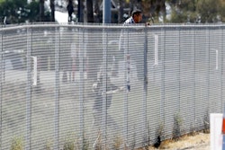 A man is detained by Border Patrol officials as he tries to climb a fence after breaching border fencing separating San Diego from Tijuana, Mexico, Tuesday, Sept. 26, 2017, in San Diego. The man, who said he was from Chiapas, Mexico, was detained by agents as they prepared for a news conference to announce that contractors have begun building eight prototypes of President Donald Trump's proposed border wall with Mexico.